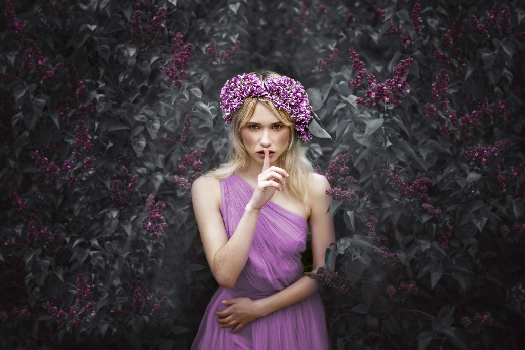 Ninfa con corona de lilas y vestido del mismo color, dentro de un bosque.