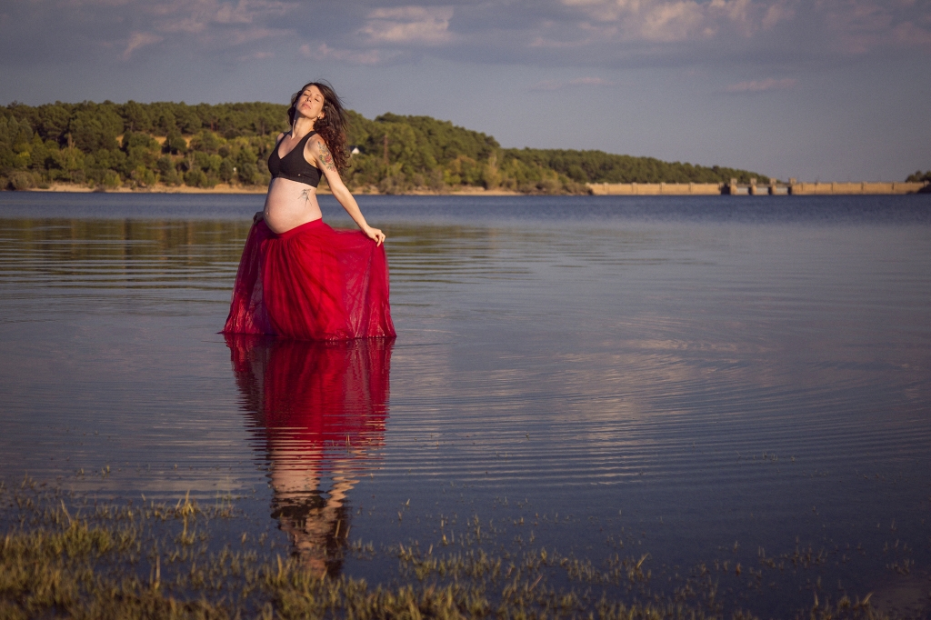 Mujer embarazada dentro del agua bailando.