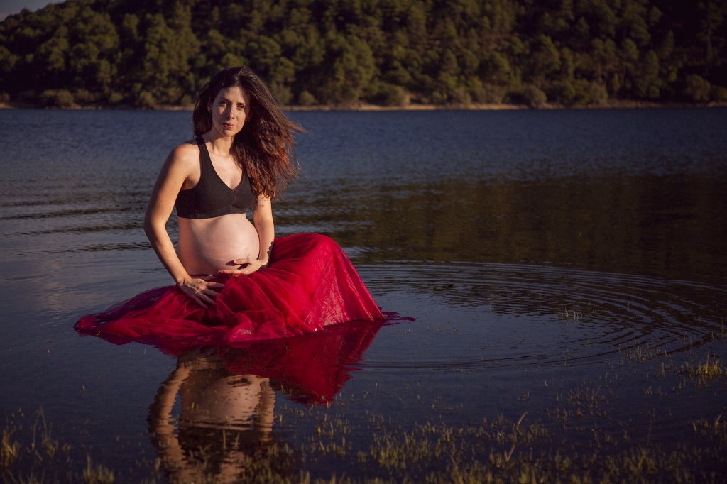 Mujer embarazada sentada dentro del agua.