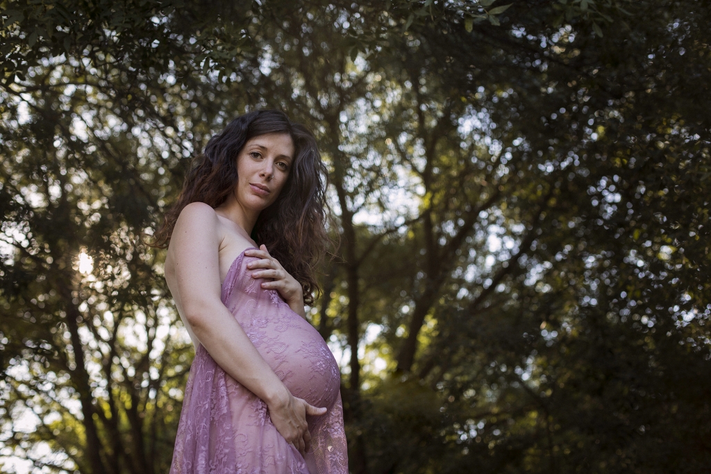 Mujer embarazada dentro de un bosque.