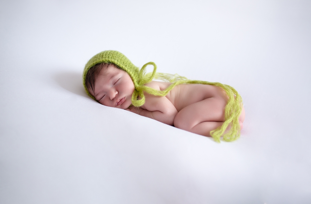 Recién nacida dormida con gorrito de angora verde.