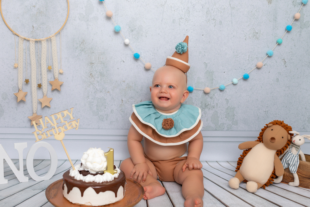 Niño de ojos azules sonriendo con su tarta de cumpleaños.